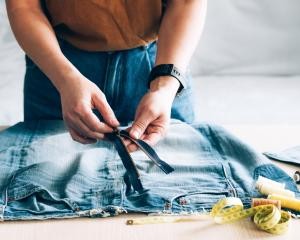 Eine Person repariert eine Jeanshose