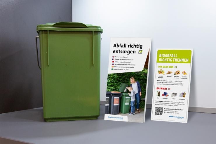 Starterset für neue Mieter In einer Küchenecke steht ein kleiner grüner Vorsortierer, das Faltblatt Trennhilfe und ein Aufkleber für den Vorsortierer.