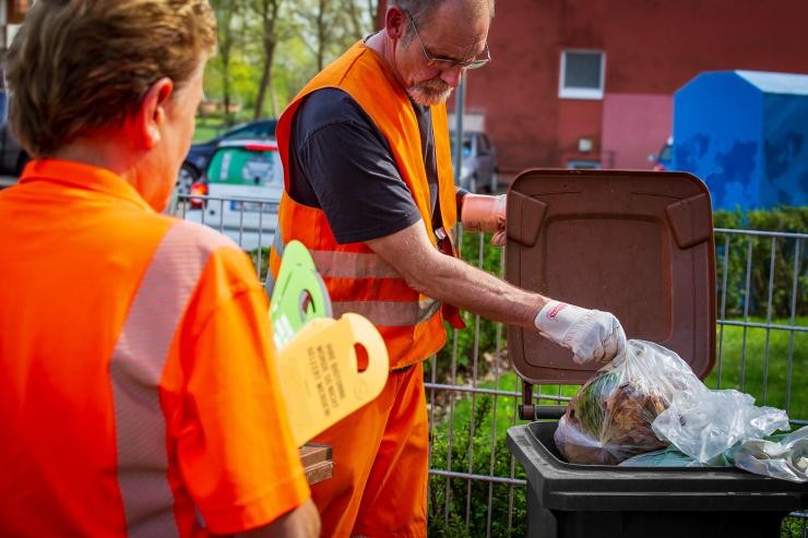Tonnenkontrollen Ein Mann und eine Frau checken die Biotonnen.