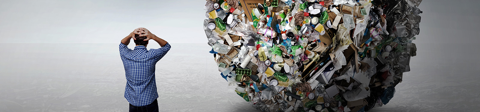 Ein Mann vor einer großen Kugel aus Verpackungen