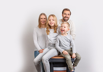 Eine Familie ist vor einer Biotonne versammelt.