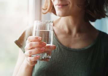 Eine Frau hält ein Glas mit Wasser